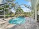 The backyard features a screened in pool, covered patio, outdoor seating, a water feature, and beautiful landscaping at 2479 Sonoma Dr W, Nokomis, FL 34275