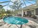 Relax by the pool, surrounded by a screened enclosure, covered patio and ample seating for entertaining at 2479 Sonoma Dr W, Nokomis, FL 34275