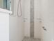 Modern walk-in shower featuring elegant white tile and a decorative mosaic accent, creating a spa-like experience at 2479 Sonoma Dr W, Nokomis, FL 34275