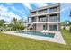 This backyard features a modern house, patio, in-ground pool, and well-manicured green lawn at 36 Dolphin Dr, Treasure Island, FL 33706