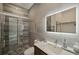 This bathroom includes a sleek vanity with a lighted mirror and a glass-enclosed shower at 36 Dolphin Dr, Treasure Island, FL 33706