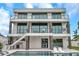 Stunning modern home featuring multiple balconies, outdoor seating, in-ground pool, and manicured lawn at 36 Dolphin Dr, Treasure Island, FL 33706