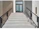 Elegant front entrance featuring concrete stairs, a sleek black handrail, and modern double front doors at 36 Dolphin Dr, Treasure Island, FL 33706