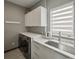 Well-equipped laundry room with modern washer and dryer, ample counter space, and storage cabinets at 36 Dolphin Dr, Treasure Island, FL 33706