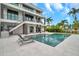 Stunning backyard pool area with comfortable lounge chairs, set against a backdrop of a modern home and tropical palm trees at 36 Dolphin Dr, Treasure Island, FL 33706