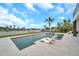 Beautiful pool with stylish lounge chairs, complemented by lush greenery and serene waterfront views at 36 Dolphin Dr, Treasure Island, FL 33706