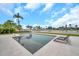 Resort-style pool with sleek lounge chairs, surrounded by tropical landscaping and a tranquil waterfront view at 36 Dolphin Dr, Treasure Island, FL 33706