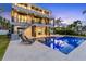 Backyard with modern pool, lounge chairs, and staircase leading to upper floors at 36 Dolphin Dr, Treasure Island, FL 33706