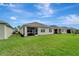 Well-maintained backyard with lush green grass, rear exterior of house, and screened lanai at 3720 Pebble Ter, Punta Gorda, FL 33980