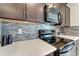 Kitchen features sleek black appliances, stylish backsplash, and quartz countertops at 3720 Pebble Ter, Punta Gorda, FL 33980