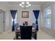 Elegant dining room with a chandelier, blue curtains, patterned chairs, and large windows at 435 Manns Harbor Dr, Apollo Beach, FL 33572