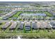 Aerial view of a community with multiple houses on a street near a retention pond at 43554 Treadway Dr, Punta Gorda, FL 33982