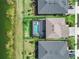 Aerial view of backyard with screened-in pool, green grass, and waterfront view at 43554 Treadway Dr, Punta Gorda, FL 33982