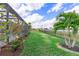 Well-manicured backyard with lush green lawn, privacy fence, and lake view at 43554 Treadway Dr, Punta Gorda, FL 33982