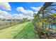 Lawn view of backyard and lake with a blossoming hibiscus plant in the foreground at 43554 Treadway Dr, Punta Gorda, FL 33982