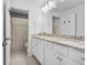 Bright bathroom with double sinks, granite countertops, white cabinets, and a shower and tub at 43554 Treadway Dr, Punta Gorda, FL 33982