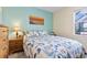 Cozy bedroom features a comfortable bed with patterned bedding and a view to the pool area at 43554 Treadway Dr, Punta Gorda, FL 33982