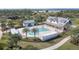 Aerial shot of a community pool, palm trees, outdoor seating, and building with a porch at 43554 Treadway Dr, Punta Gorda, FL 33982