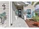Welcoming front door with a wreath, decorative plants, and charming turquoise chairs on the porch at 43554 Treadway Dr, Punta Gorda, FL 33982