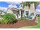 Inviting front entrance featuring a stylish black door, potted plants, and cheerful turquoise chairs at 43554 Treadway Dr, Punta Gorda, FL 33982