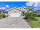 Beautiful two-story home with gray siding, a large brick driveway, and well-maintained landscaping at 43554 Treadway Dr, Punta Gorda, FL 33982