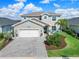 Charming two-story home with a brick driveway, manicured lawn, and delightful turquoise shutters at 43554 Treadway Dr, Punta Gorda, FL 33982