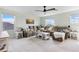 Spacious living room features a large sectional sofa, multiple windows, and a modern ceiling fan at 43554 Treadway Dr, Punta Gorda, FL 33982