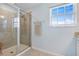 Modern bathroom showcasing a glass-enclosed shower with tile surround and a window providing natural light at 43554 Treadway Dr, Punta Gorda, FL 33982
