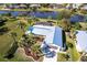 An aerial view showcases a property with a new metal roof, palm trees, and a pool with a screened enclosure at 483 Corrientes Cir, Punta Gorda, FL 33983