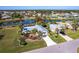 Aerial view of a beautiful home with screened-in pool, well-manicured landscaping, and waterfront access at 483 Corrientes Cir, Punta Gorda, FL 33983