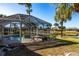 Spacious backyard featuring a screened-in pool area and lush green lawn extending to a scenic pond at 483 Corrientes Cir, Punta Gorda, FL 33983