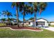 Well-maintained single-story home featuring mature landscaping, a two-car garage, and a metal roof at 483 Corrientes Cir, Punta Gorda, FL 33983
