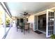 Covered outdoor patio boasts a ceiling fan, dining set, and direct access to the home through glass doors at 483 Corrientes Cir, Punta Gorda, FL 33983