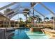 Inviting screened-in pool and spa with serene pond views and tropical landscaping at 483 Corrientes Cir, Punta Gorda, FL 33983