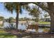 Inviting backyard with mature trees, a wooden swing, and tranquil canal views at 2012 River Basin Ter, Punta Gorda, FL 33982