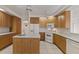Spacious kitchen with an island sink, wood cabinets, and modern white appliances at 2012 River Basin Ter, Punta Gorda, FL 33982