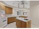 Classic kitchen with wood cabinets, an island with a sink, and bright lighting at 2012 River Basin Ter, Punta Gorda, FL 33982