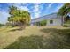 Backyard view of screened in pool, tropical plants and house exterior at 3487 Cabaret St, Port Charlotte, FL 33948