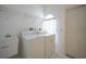 Bright laundry room with washer, dryer, utility sink and white tiling at 3487 Cabaret St, Port Charlotte, FL 33948