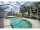 Inviting screened-in pool with ample deck space, surrounded by lush greenery at 3487 Cabaret St, Port Charlotte, FL 33948
