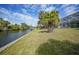 Scenic waterfront backyard with boat dock, grassy lawn and tropical trees at 3487 Cabaret St, Port Charlotte, FL 33948