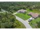 An aerial view of a house with a green lawn surrounded by mature trees at 5366 Dunsmuir Rd, North Port, FL 34288