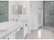 Bathroom featuring a double sink vanity, walk-in shower, and serene natural stone accents at 5366 Dunsmuir Rd, North Port, FL 34288