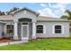 Charming front entrance with beautiful columns, arched window accents, and freshly manicured lawn at 5366 Dunsmuir Rd, North Port, FL 34288