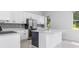 Modern white kitchen featuring an island with white countertop and stainless steel refrigerator at 5366 Dunsmuir Rd, North Port, FL 34288