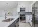 Kitchen featuring stainless steel appliances, quartz countertops, and dark lower cabinetry at 5366 Dunsmuir Rd, North Port, FL 34288