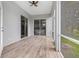 A screened in lanai features wood-look tile and a ceiling fan at 5366 Dunsmuir Rd, North Port, FL 34288