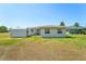 Backyard view of house with a shed and grassy area at 556 Lowell Nw Ave, Port Charlotte, FL 33952