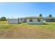 Backyard view of house with a shed and grassy area at 556 Lowell Nw Ave, Port Charlotte, FL 33952