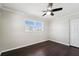 This bedroom features dark wood flooring, a ceiling fan, and a window that provides natural light at 556 Lowell Nw Ave, Port Charlotte, FL 33952